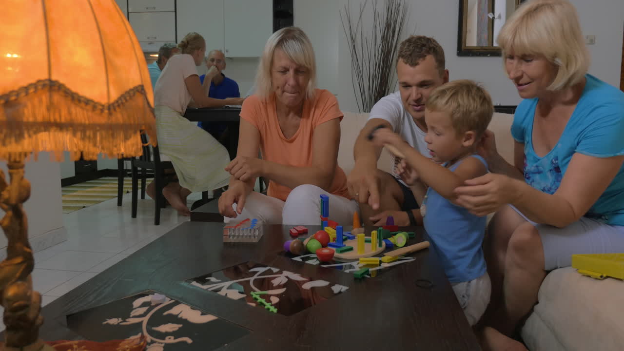 Niño y su familia jugando con juguetes en casa