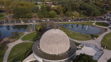 drone flight over the planetario building in buenos aires argentina with the busy road and lakes in the background