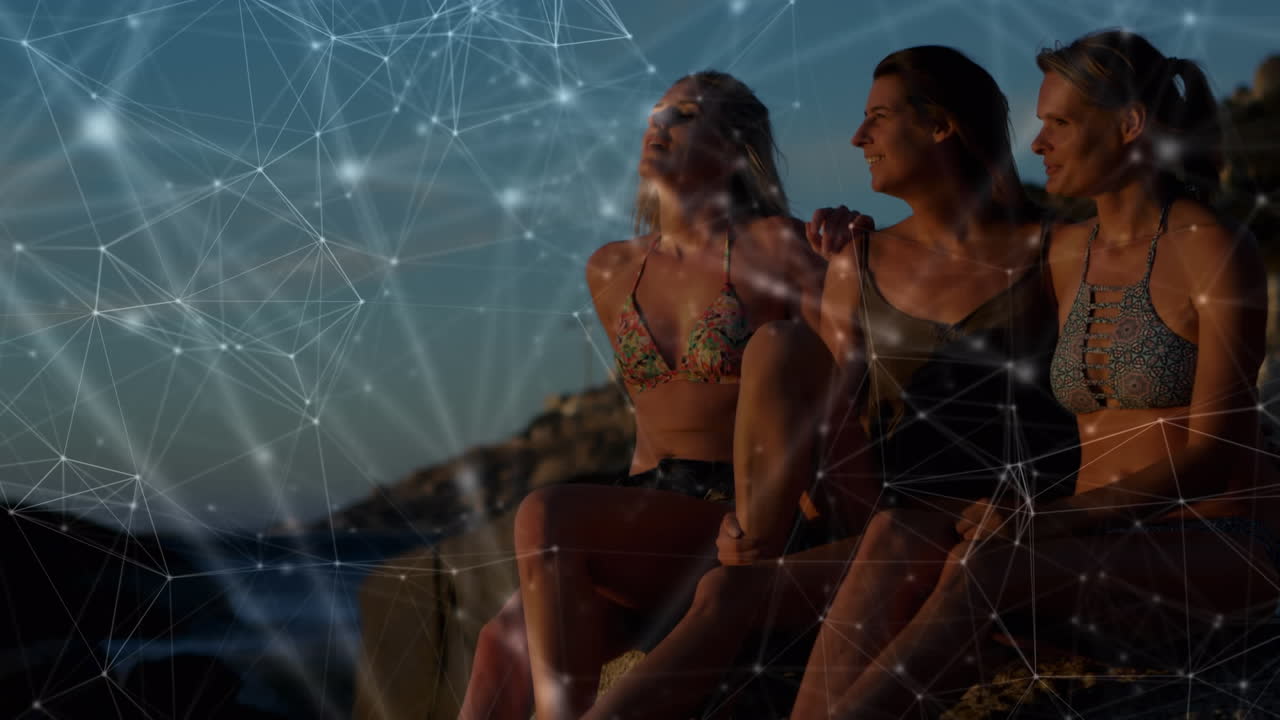 animación de una red de conexiones sobre amigas abrazándose en la playa