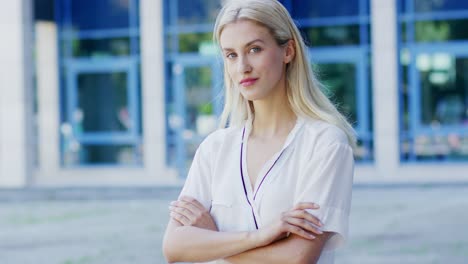 positive woman standing near building