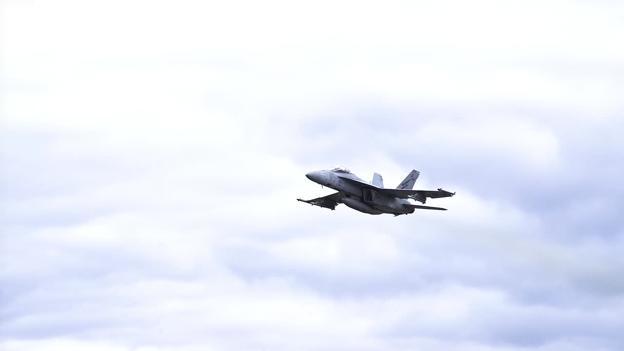 fa 18f super hornet jet volando a través del cielo nublado - ángulo bajo