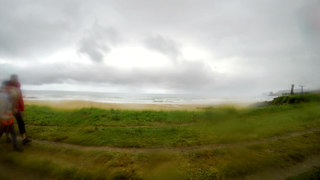 padre, madre y hijo pequeño caminando juntos por el famoso camino de santiago o "el camino de san santiago" durante el día lluvioso. imágenes con gotas de lluvia en el vidrio de la lente.