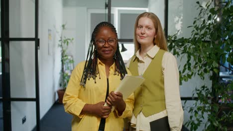 two businesswomen in office corridor