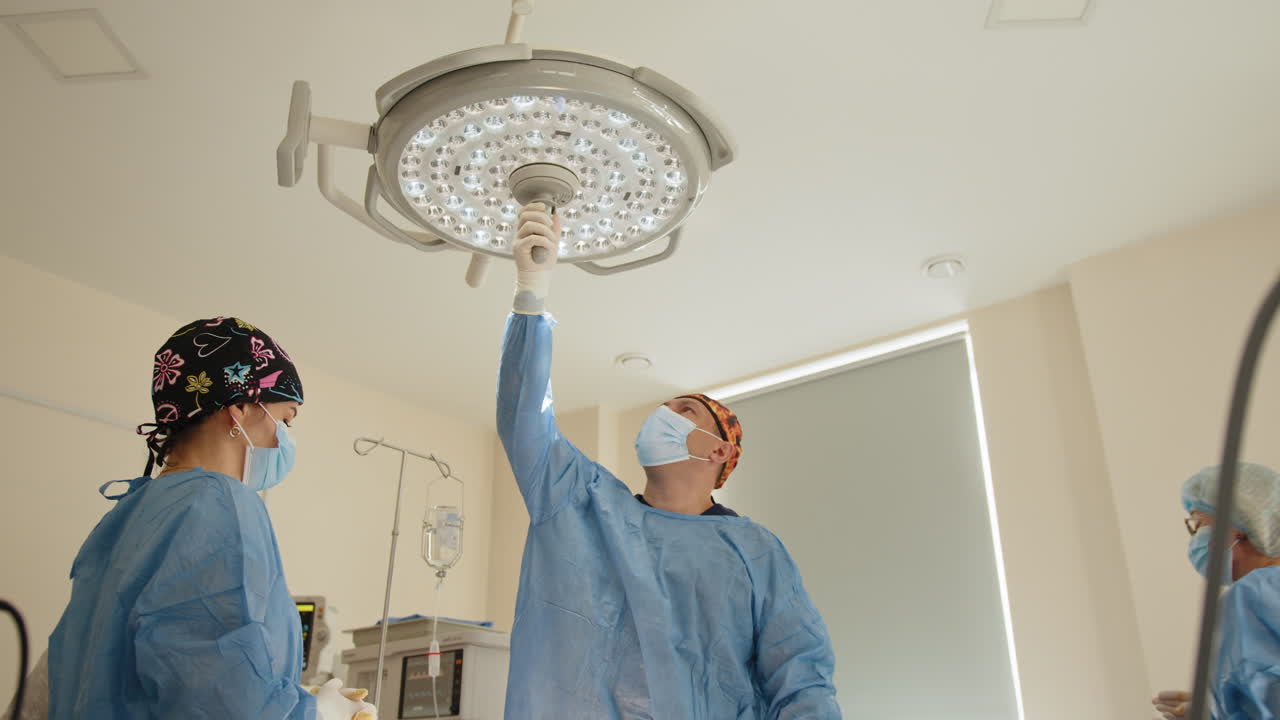 수술실에서 천장 조명을 조정하는 의료진