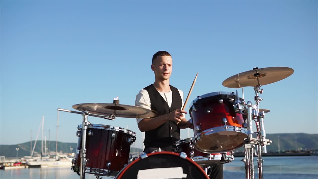 Drummer Playing Drums by the Harbor
