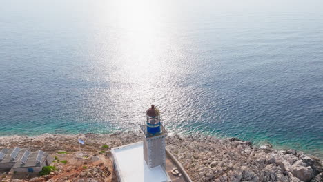 drone glides across sparkling sea surface near cape tainaron, sunlight reflects off blue water