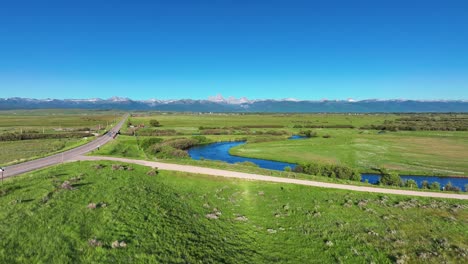 Aerial-View-Of-River-Flowing-Through-Rural-Fields-In-Saint-Anthony,-Idaho,-United-States---drone-shot