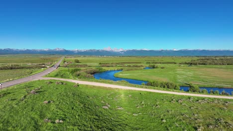 aerial view of river flowing through rural fields in saint anthony, idaho, united states - drone shot