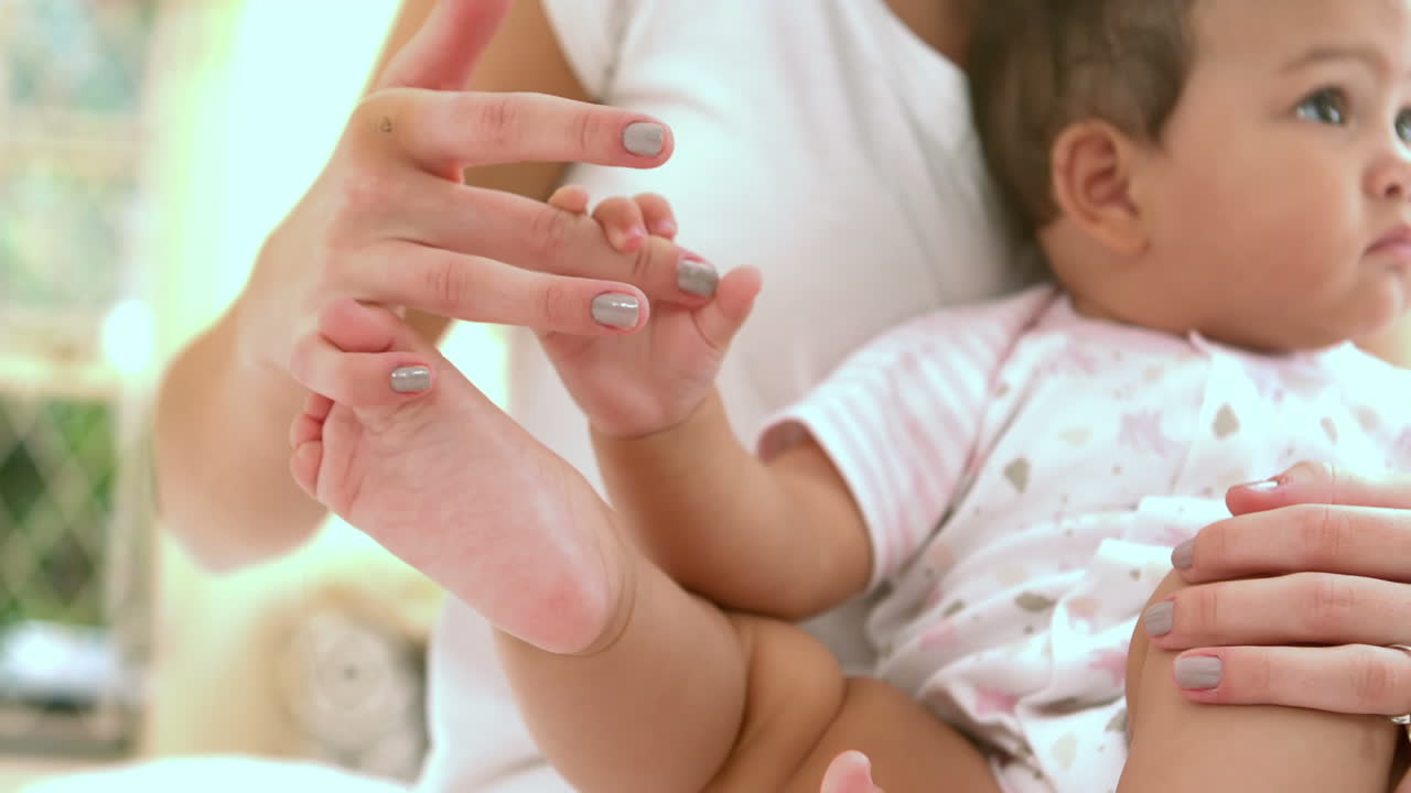 hija bebé sosteniendo el dedo de la madre