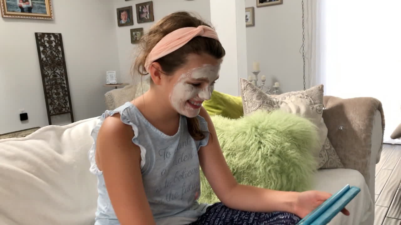 Little girl talking on tablet computer in living room