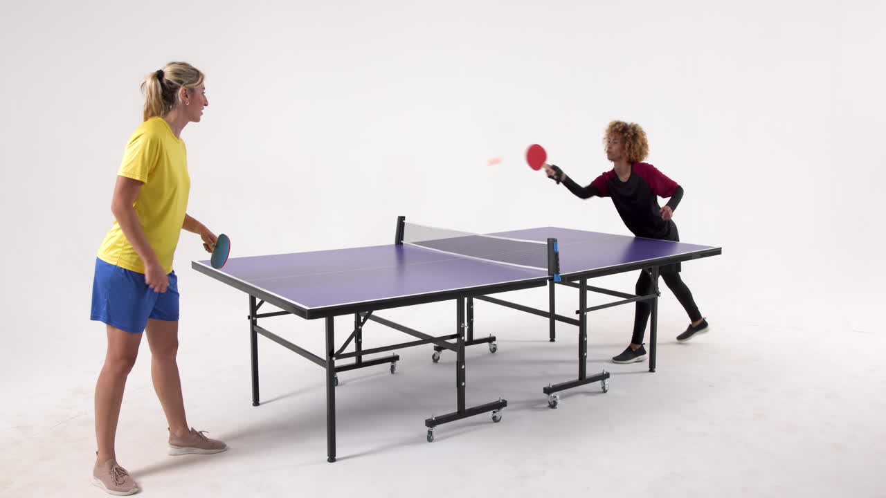 Multiracial female table tennis players, serving and passing the ball on white background