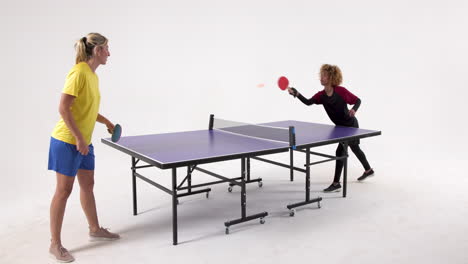 multiracial female table tennis players, serving and passing the ball on white background