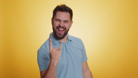 caucasian man showing rock n roll gesture by hands cool sign crazy expression dancing celebrating