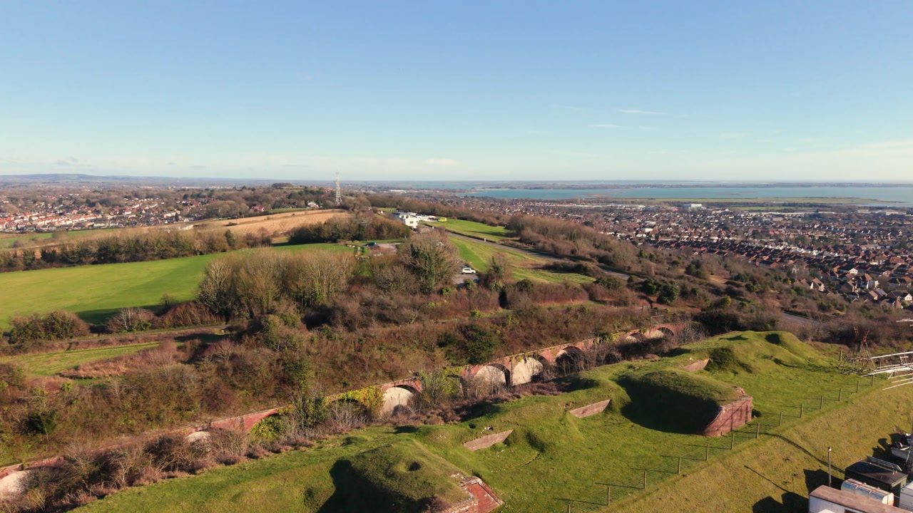 Fort Widley Swanick Hill Portsmouth, low flight over the repurposed military fort looking across Portsmouth and out to the Solent detail of fortifications and caravans on site in bright sunshine