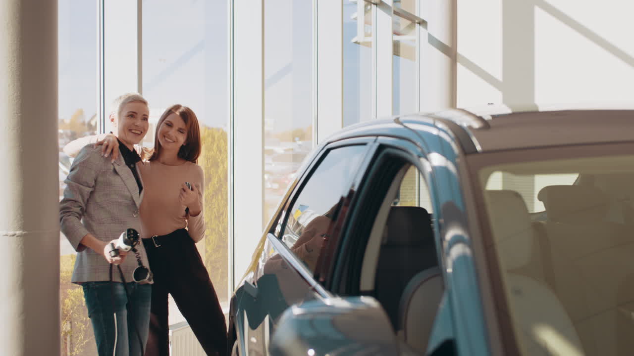 Women Shopping for an Electric Car in a Showroom