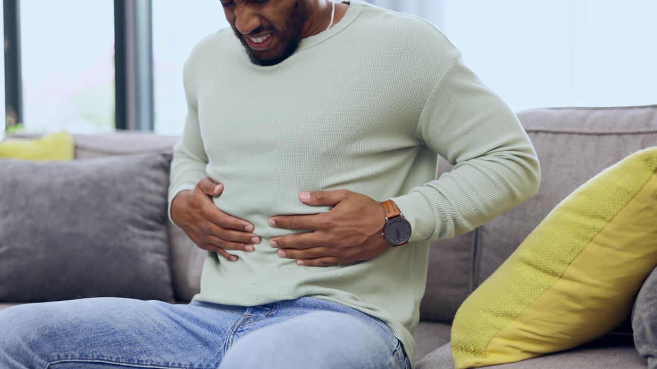 Man on a sofa with stomach pain
