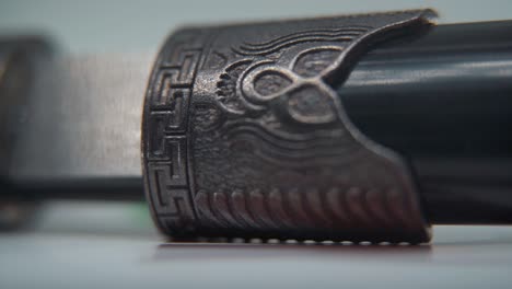 a macro shot of two ancient silver knifes opening, chinese antique weapon, historical vintage blade, old textured steel, traditional dagger, professional lighting, cinematic slow motion 120 fps