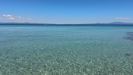 stunning beach scene in halkidiki, greece, with elegant sunbeds facing the crystal-clear turquoise sea. a perfect summer escape in the heart of the aegean.