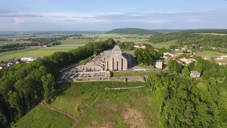 Vista-De-Una-Iglesia-En-Una-Colina-En-Dun-Sur-Meuse,-Francia.-De-Cerca-A-Lejos-Con-Drones