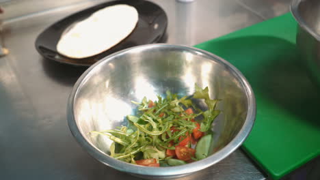 chef cooking salad in a professional kitchen in a restaurant. hands close up