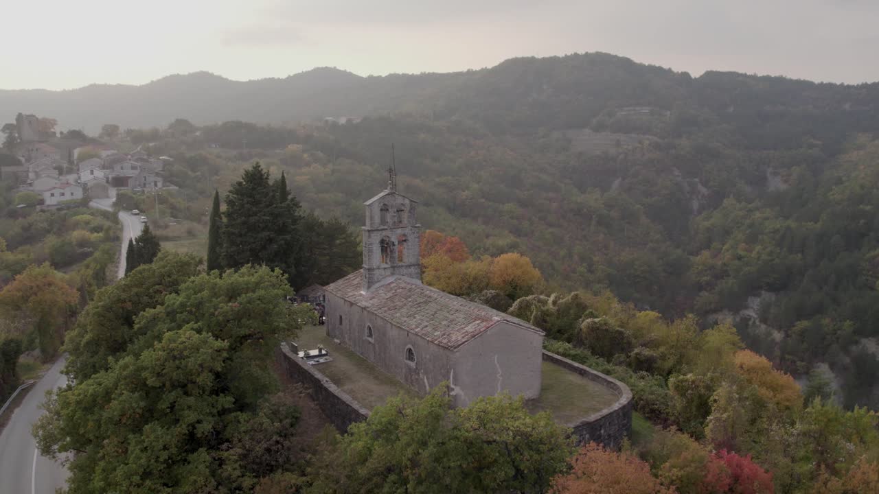 Coucher de soleil sur l'église Saint-Guy avec un cimetière voisin et une forêt automnale, Cerovlje, Croatie