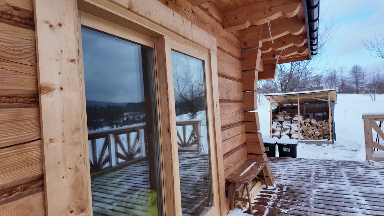 Esterno di baita rustica in legno in un paesaggio invernale innevato