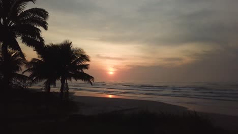 disparo de avión no tripulado del amanecer del cielo naranja sobre la playa del océano con olas en brasil