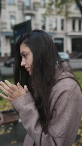 woman in a brown coat in a park