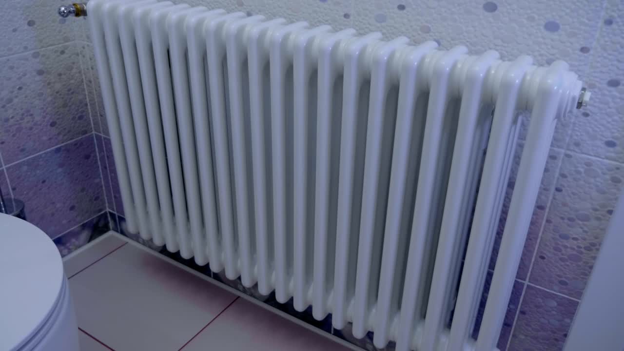 Beautiful white radiator (battery, heated towel rail) in the bathroom