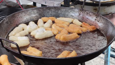 cooking dough snacks in bubbling hot oil