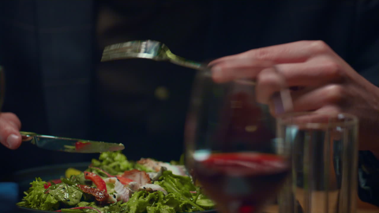 럭셔리 레스토랑에서 저녁을 먹는 즐거운 남자. 예쁜 신사 숙녀가 음식을 즐긴다.