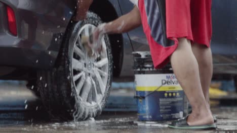 stabilized spot of a person cleaning a car tire with foam and water. circular movements.