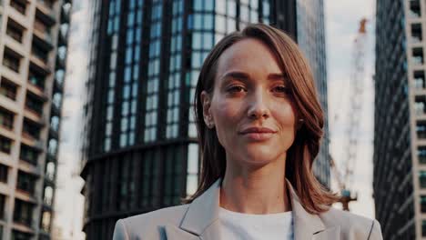 young female architect stands confidently amidst modern urban architecture, her composed demeanor reflecting a successful career in design and construction