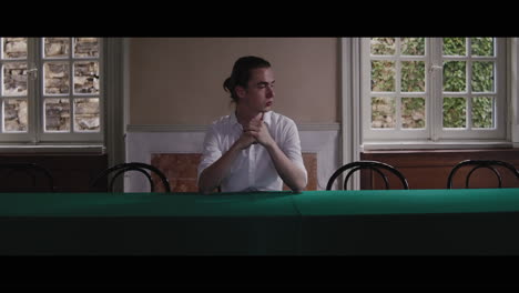 man sitting at a table in a historic room