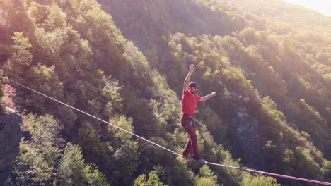 man slacklining on mountain ridge