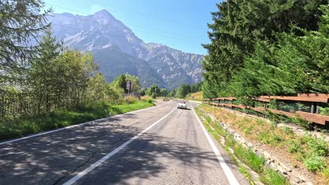 mountain road with cars and lush greenery