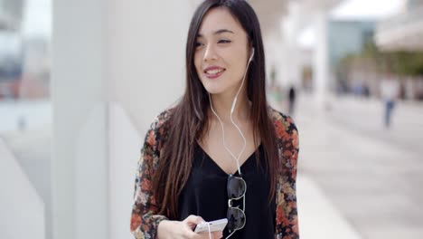 Smiling-young-woman-walking-through-town