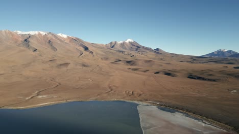 Lagunas-Route-Bolivia,-Aerial-Above-Surreal-Landscape,-Blue-Water-Volcanic-Rock-Formations,-Altitude-Mountains-in-Dune-Terrain,-South-America-Travel-and-Tourism