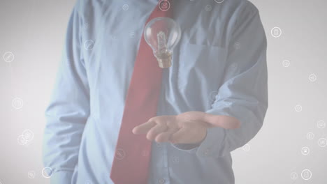 animación de iconos de medios sobre un hombre de negocios lanzando y atrapando una bombilla