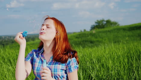 red-haired teen girl playing with soap bubbles