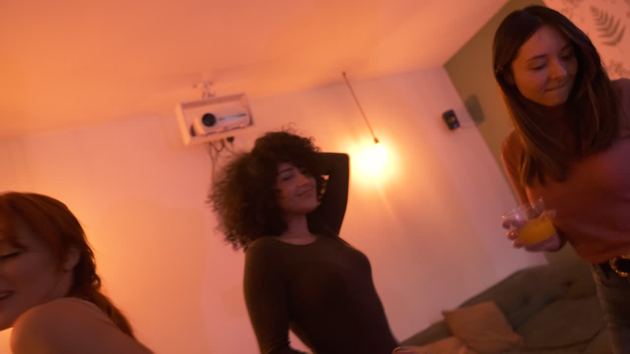 Cheerful diverse friends dancing with drinks at party