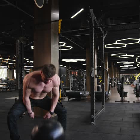 athletic shirtless man training in gym. fitness athlete training intense workout in gym