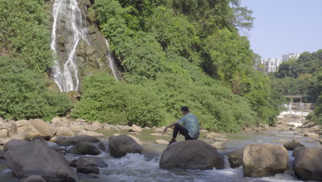 el hombre está disfrutando del paisaje en el arroyo