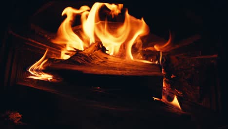 wood burning in the fireplace with red hot coals - close up