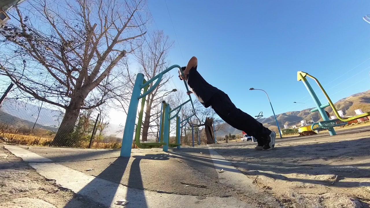 Athletic man working out in the park, performing incline push-ups to stay fit and strong