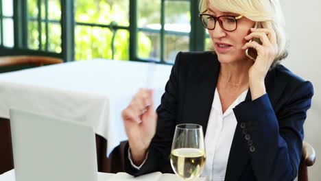 businesswoman writing on diary while talking on mobile phone 4k