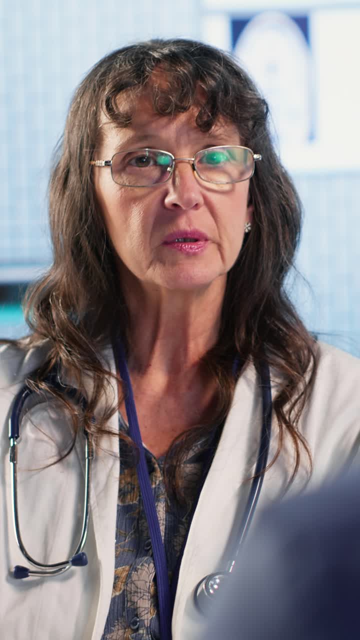 Vertical Video Senior woman evaluating diagnostic results with her medic in a cabinet