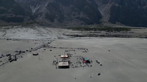 Vista-Aérea-Del-Evento-De-Rally-De-Jeep-Sarfaranga-En-Skardu-Con-Montañas-Al-Fondo-En-Pakistán