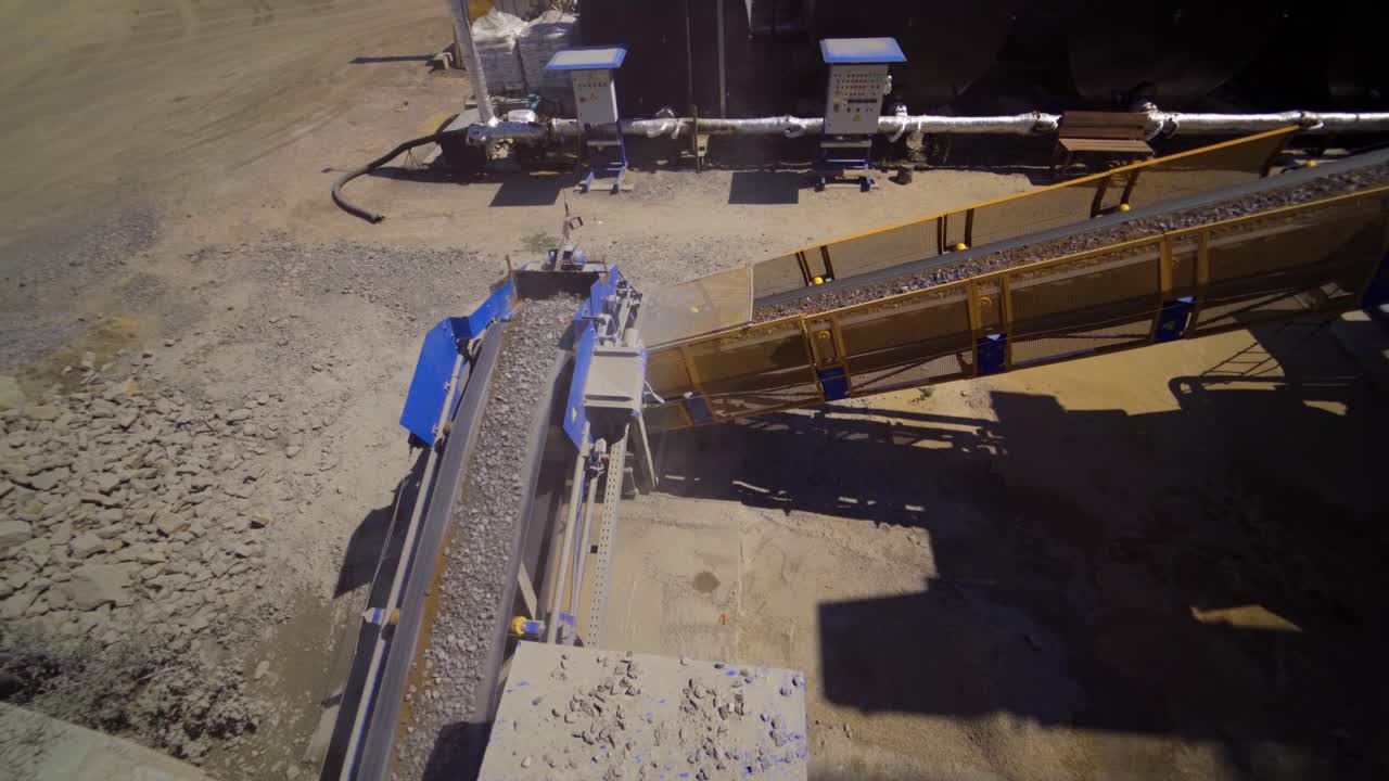 Asphalt plant outdoors. Aerial view on the modern equipment for asphalt production. Gravel moves up on conveyor.