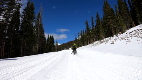 driving past a line of snowmobiles in the mountains
